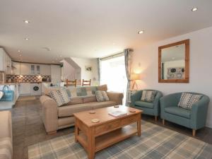un salon avec un canapé, deux chaises et une table dans l'établissement Croft Cottage, à Alnwick