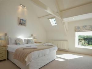 une chambre blanche avec un lit et une fenêtre dans l'établissement Croft Cottage, à Alnwick