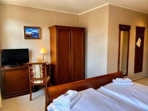 a hotel room with a bed and a tv at Pension Töpferhof in Tangermünde