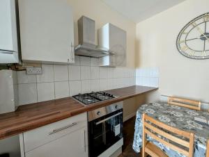 a kitchen with a stove and a counter top at Cosy Single Room near Heathrow Airport in Hounslow