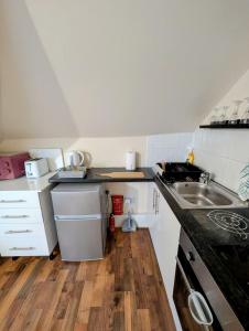 a small kitchen with a sink and a stove at Cosy Loft Studio in Town Centre in Hounslow