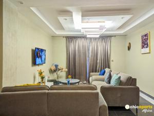 a living room with two couches and a table at Chic apart with parking near the airport in Douala