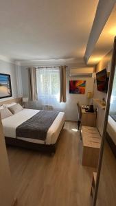 Кровать или кровати в номере Hotel Miramar- Cap d'Antibes - La Garoupe plage