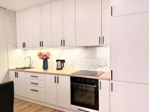 a white kitchen with white cabinets and a sink at Найкращий ЖК Києва Файна Таун ГЕНЕРАТОР для опалення та води in Kyiv