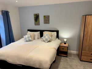 une chambre avec un grand lit blanc avec des oreillers dans l'établissement Fletcher - A Converted Church Luxe Apartment, à Gillingham