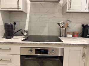 une cuisine avec un évier et une cuisinière four supérieur dans l'établissement Fletcher - A Converted Church Luxe Apartment, à Gillingham 6 autres photos