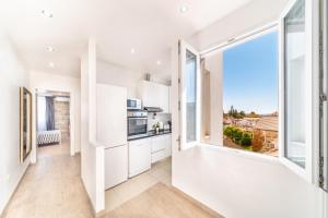 a kitchen with white cabinets and a large window at Apartment Lilly in Split