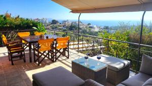 Un patio con una mesa y sillas en un balcón. en Complex HARMONY with infinity pool, en Kalívia Thorikoú
