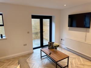 a living room with a coffee table and a tv at Hurley - A Converted Church Luxe Apartment in Gillingham