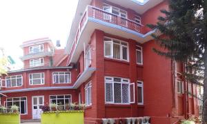 un edificio rosso con finestre bianche e balconi di My Garden House a Kathmandu