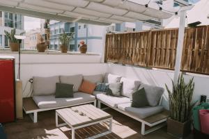 a patio with a couch and a coffee table at Kite & Surf Nomad House in Las Palmas de Gran Canaria