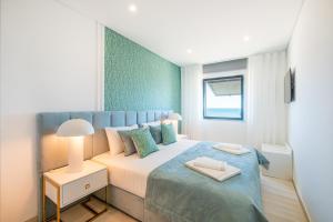 a bedroom with a large bed with a blue blanket at Sob O Mar III in Armação de Pêra +23 photos