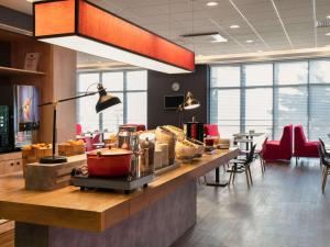 a restaurant with a counter with a food at ibis Ankara Airport Hotel in Ankara