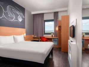 a hotel room with a large bed and a tv at ibis Ankara Airport Hotel in Ankara