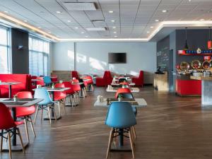 a restaurant with red and blue chairs and tables at ibis Ankara Airport Hotel in Ankara