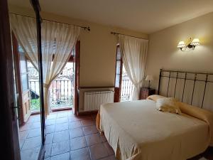 a bedroom with a bed in a room with windows at Casa Rural El Canónigo in Mantiel