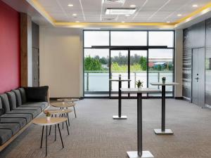 a lobby with a couch and tables and a large window at ibis Ankara Airport Hotel in Ankara