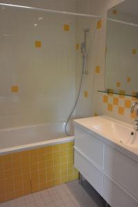 a bathroom with a tub and a sink and a mirror at Agréable villa fleurie sur l'ile de Porquerolles in Porquerolles +12 photos