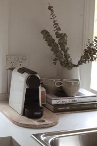 a kitchen counter with a toaster and books and a plant at Train Carriage Tiny Home in the Byron Hinterland in Alstonvale +17 photos
