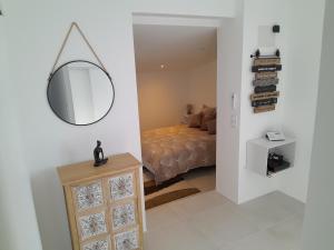 a bedroom with a bed and a mirror on the wall at MAISON au calme en pleine nature 2 PERSONNES in Fayence