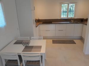 a kitchen with a white table and white cabinets at MAISON au calme en pleine nature 2 PERSONNES in Fayence
