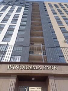 ein hohes Gebäude mit einem Schild für Panoramapark in der Unterkunft ЖК Панорама Парк in Qostanai