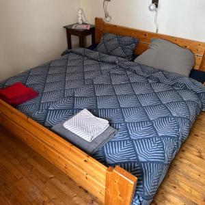 ein Bett mit einer blau-weißen Bettdecke darauf in der Unterkunft Lofotenhaus direkt am Skjelfjord in Skjelfjord