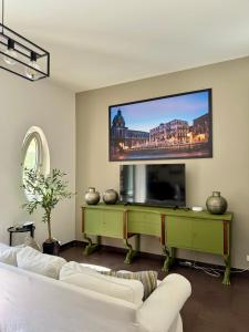 un soggiorno con un divano bianco e una TV a schermo piatto di Flat44 a Palermo