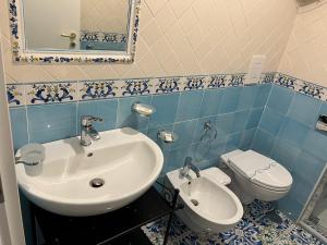 a blue and white bathroom with a sink and a toilet at Dimora Carlo III in Vietri sul Mare