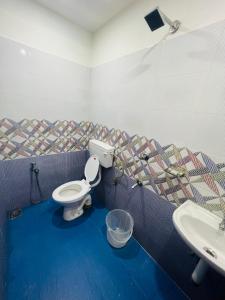 a bathroom with a toilet and a sink at Heres Haut Residency in Ernakulam