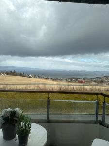a balcony with a table and a view of a field at 3-room downtown apartment in Trondheim