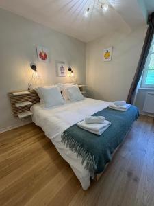 a bedroom with a large bed with two towels on it at Le Moulin , Cinema , Terrain Tennis BY PRIMO C0NCIERGERIE in Cuisery