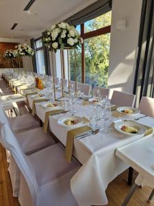 a long dining room with white tables and chairs at Zamek Księża Góra in Karpacz