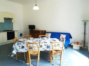 a dining room with a table with chairs and a blue couch at Afr0dite'home Historic Center Otranto Seafront in Otranto