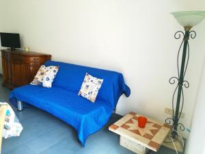a blue couch in a living room with a table at Afr0dite'home Historic Center Otranto Seafront in Otranto
