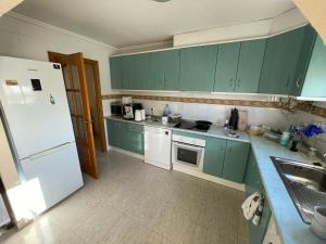 eine Küche mit grünen Schränken und einem weißen Kühlschrank in der Unterkunft Maison type villa 4 façades 4 bedrooms in Gran Alacant