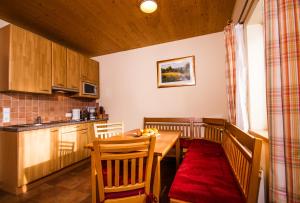 une cuisine avec une table en bois et des comptoirs de cuisine dans l'établissement Monarchia Park, à Lachtal