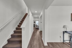 a staircase in a house with white walls and wood floors at Quiet Retreat Perfect for Families in Rocky Mount