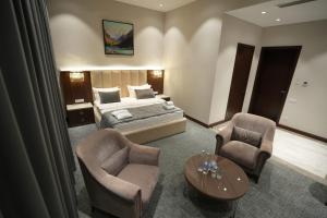 a bedroom with a bed and two chairs and a table at CONTINENTAL DARVOZ Hotel in Dashtak