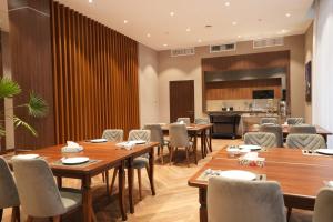 a restaurant with wooden tables and chairs and a kitchen at CONTINENTAL DARVOZ Hotel in Dashtak