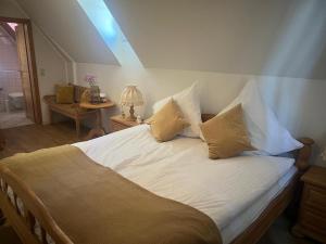 a bedroom with a bed with white sheets and pillows at Landgasthaus Zum Engel in Neuleiningen