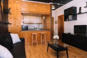 a living room with a couch and a table and a kitchen at Calma en primera línea de playa by CABANA Rentals in Vigo
