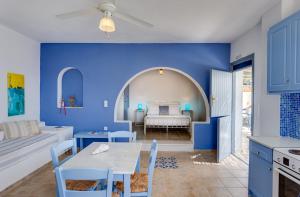 a blue room with a table and a bed at Althea Studios in Donoussa