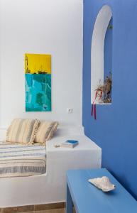 a bedroom with a bed and a blue table at Althea Studios in Donoussa