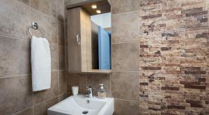 a bathroom with a sink and a mirror at Althea Studios in Donoussa