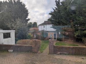 a brick fence in front of a house at Gordon Avenue Guest House HA7 London in Busheyheath