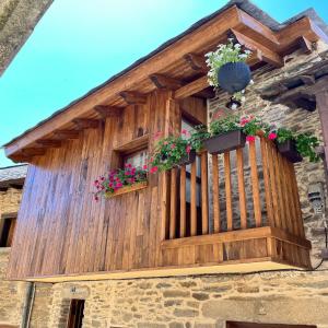 a wooden balcony with flowers on a building at Casa la florida in Puebla de Sanabria