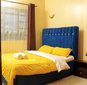 a blue bed with two towels on top of it at Bantu's Vista in Meru