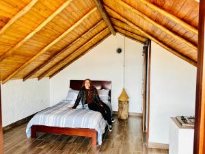 a woman sitting on a bed in a room at Toscana Romántica in Guatavita