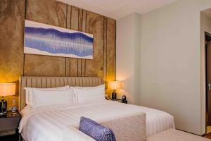 ein Schlafzimmer mit einem großen weißen Bett und einem Stuhl in der Unterkunft Pan Pacific Serviced Suites Nairobi in Nairobi + 76 Fotos